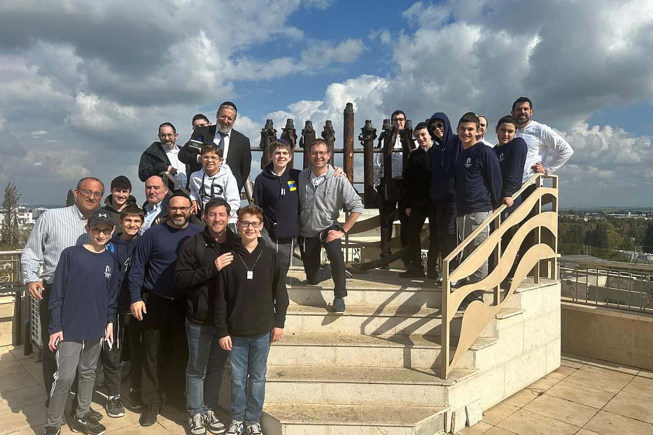 Participants of the OU Father-Son Israel Mission pose on the roof of the Hesder Yeshiva of Sderot with a menorah made of rockets fired from Gaza. Credit: Courtesy of the Orthodox Union.