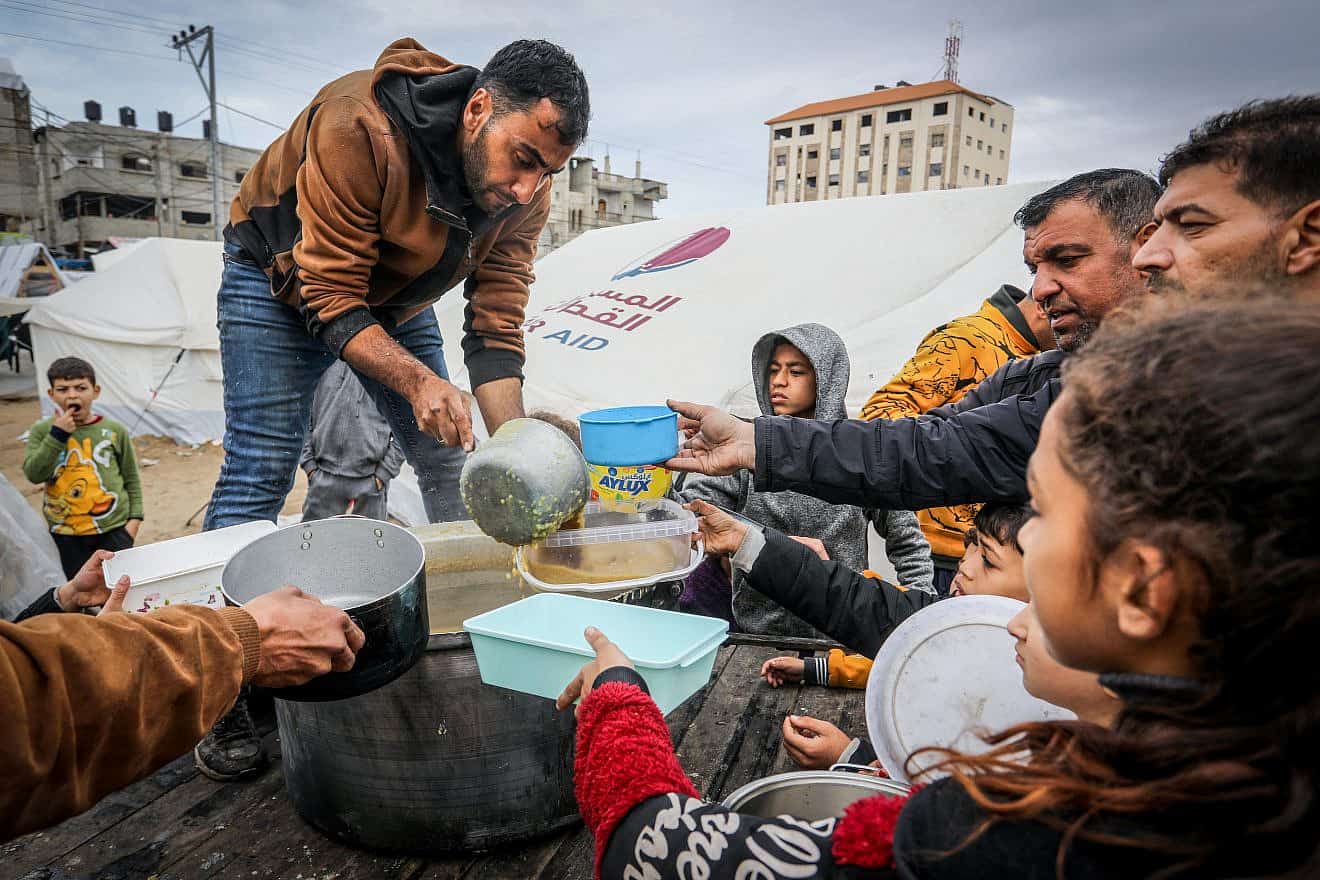 A Palestinian distributes food to displaced people in Rafah, in the southern Gaza Strip, Feb. 18, 2024. Photo by Abed Rahim Khatib/Flash90.