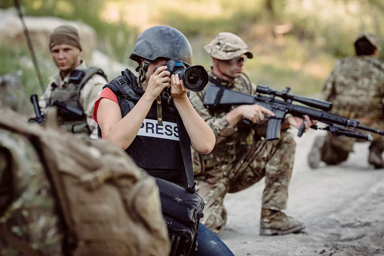 Stock photo of journalist covering war. Credit: Presslab/Shutterstock.