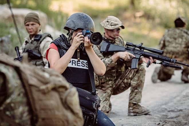 Stock photo of journalist covering war. Credit: Presslab/Shutterstock.