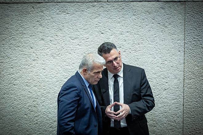 Israeli opposition leader Yair Lapid speaks with New Hope Party leader Gideon Sa'ar (right) at the plenary hall of the Israeli parliament in Jerusalem, March 13, 2024. Photo by Yonatan Sindel/Flash90.