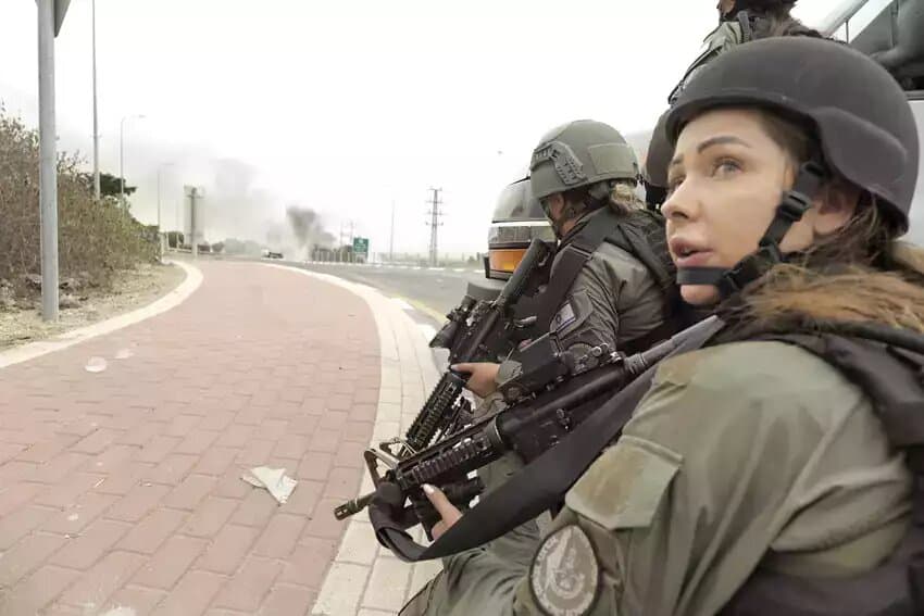 A group of female border police officers in uniform, their faces obscured by helmets and sunglasses, standing in formation. The image evokes a sense of discipline and duty, but also the erasure of individual identity in service to a system.