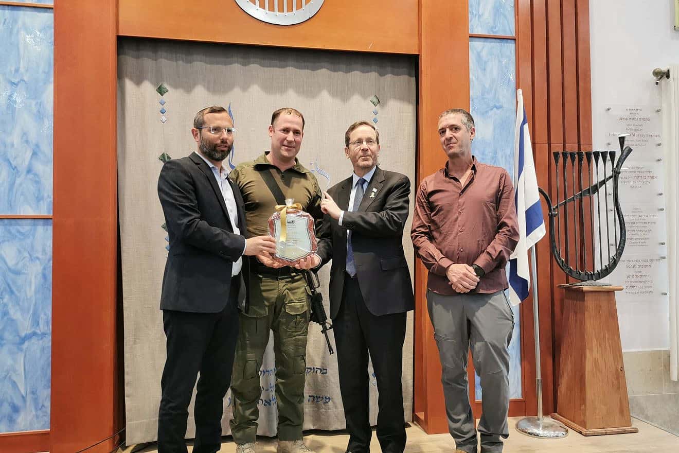 Aviad Gizbar (second from left) receives a certificate of appreciation from Israeli President Isaac Herzog and Binyamin Regional Council head Israel Ganz (left). Credit: Binyamin Regional Council.