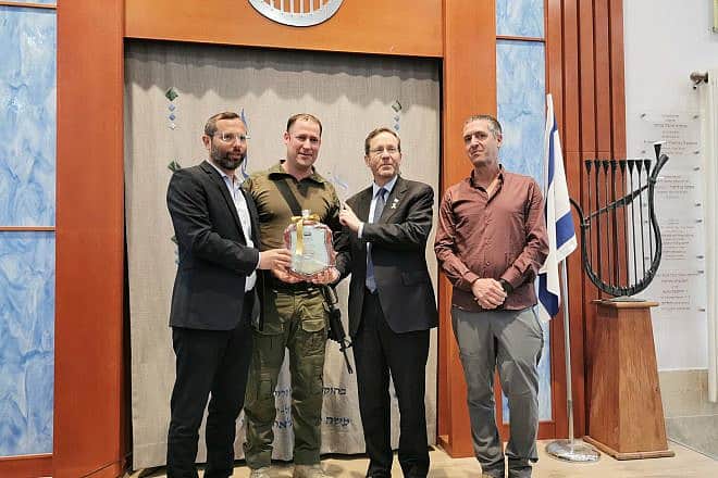 Aviad Gizbar (second from left) receives a certificate of appreciation from Israeli President Isaac Herzog and Binyamin Regional Council head Israel Ganz (left). Credit: Binyamin Regional Council.