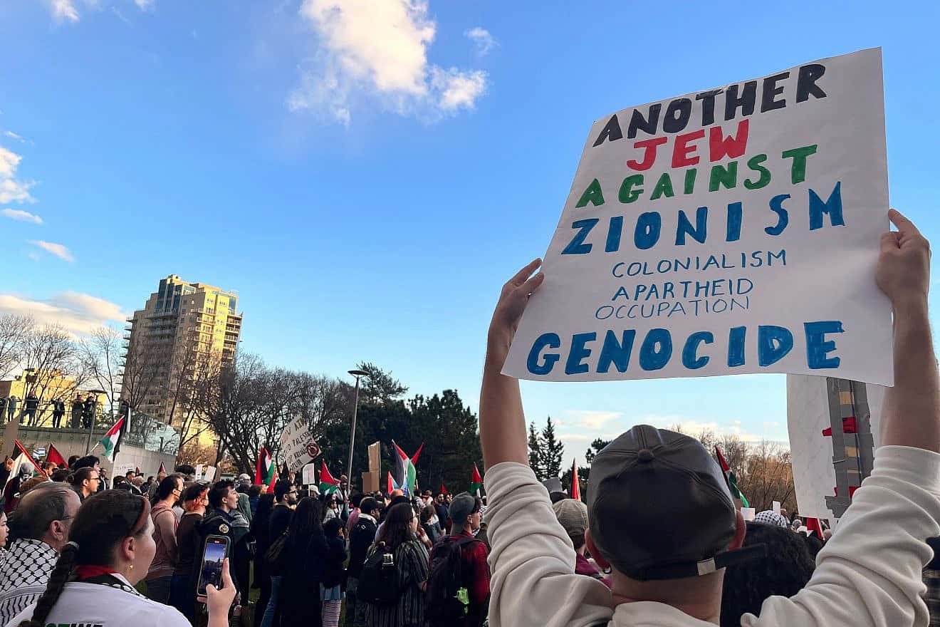 A person holds a sign reading “Another Jew Against Zionism, Colonialism, Apartheid, Occupation, Genocide” at a protest at the Alberta Legislature in Edmonton, Canada, on Oct. 18, 2023. Credit: Jenari/Shutterstock.