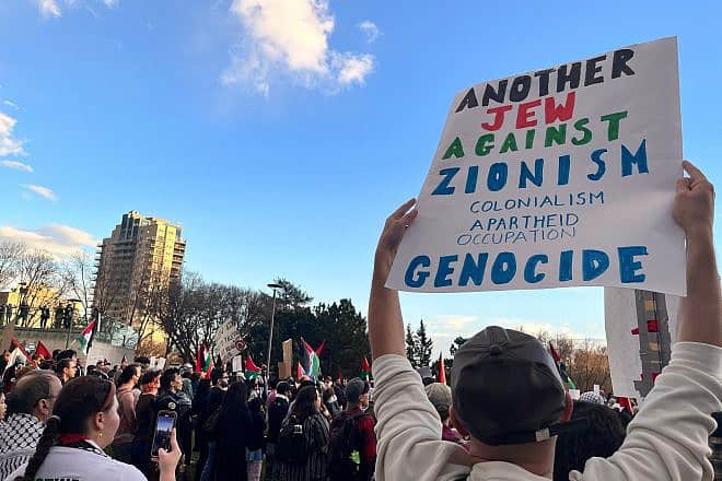 A person holds a sign reading “Another Jew Against Zionism, Colonialism, Apartheid, Occupation, Genocide” at a protest at the Alberta Legislature in Edmonton, Canada, on Oct. 18, 2023. Credit: Jenari/Shutterstock.