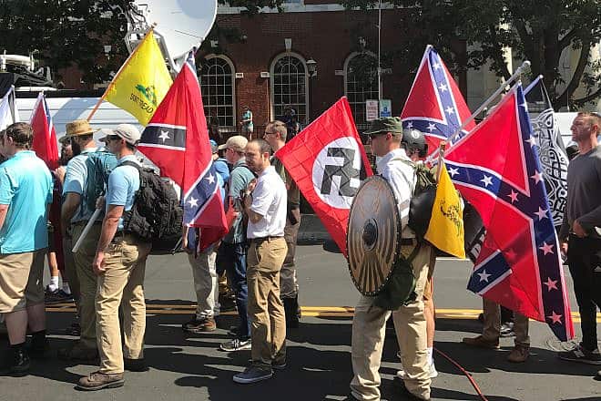 Alt-right members preparing as part of the “Unite the Right” rally in Charlottesville, Va., hold Nazi, Confederate and Gadsden “Don't Tread on Me” flags, Aug. 12, 2017. Credit: Beyond My Ken via Wikimedia Commons.