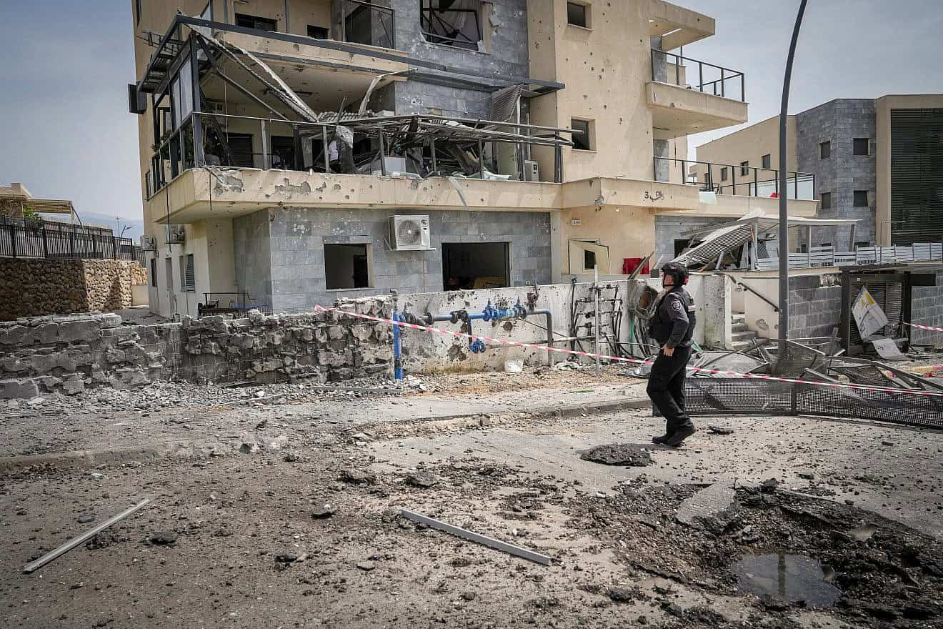 An Israeli solder views the damage after a rocket fired by Hezbollah in Lebanon hit the Galilee city of Kiryat Shmona, March 27, 2024. Photo by Ayal Margolin/Flash90.