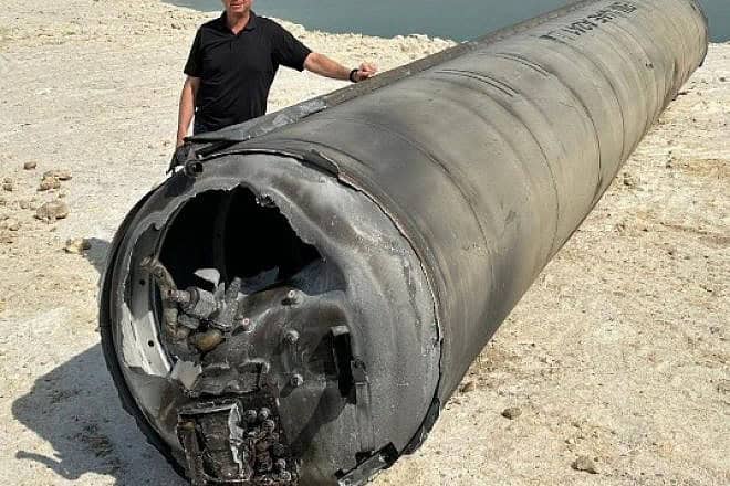 An Israeli stands next to the remains of an intercepted Iranian ballistic missile next to the Dead Sea following the missile barrage on April 13-14, 2024. Source: X.