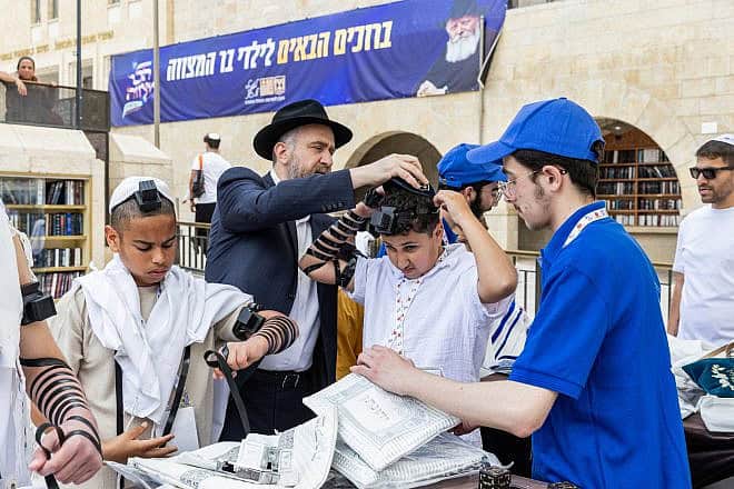 Refael (center) celebrates his bar mitzvah as part of an event organized by Colel Chabad. Credit: Mendy Kornet.