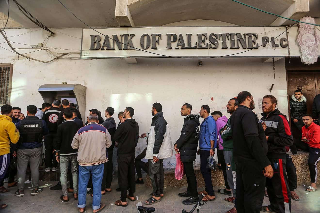 Palestinians line up at an ATM outside a Bank of Palestine branch in Rafah in the southern Gaza Strip, Dec. 8, 2023. Photo by Abed Rahim Khatib/Flash90.