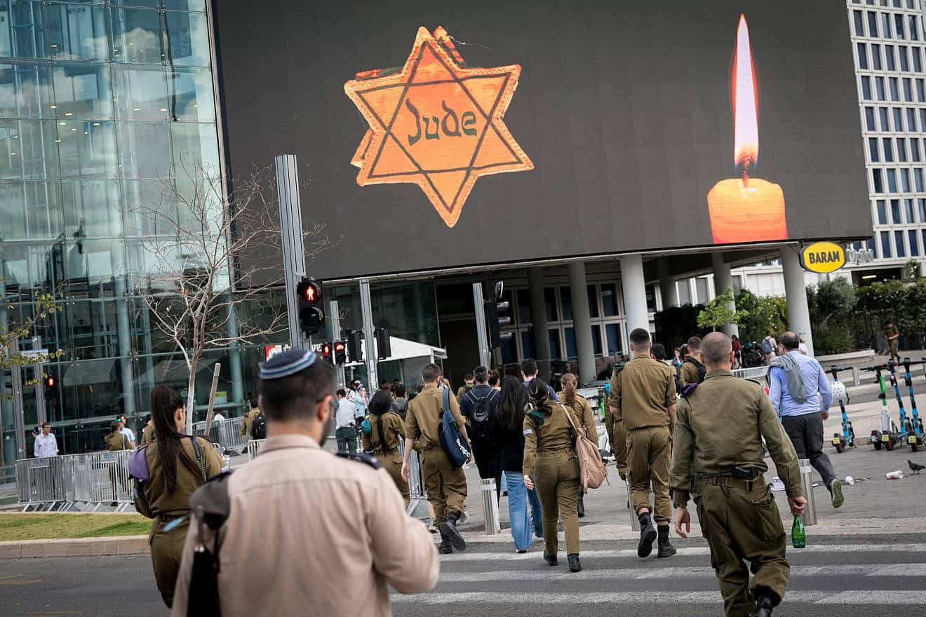 People walk by a Star of David reading "Jude" in Tel Aviv on Holocaust Remembrance Day. May 6, 2024. Photo by Miriam Alster/Flash90.