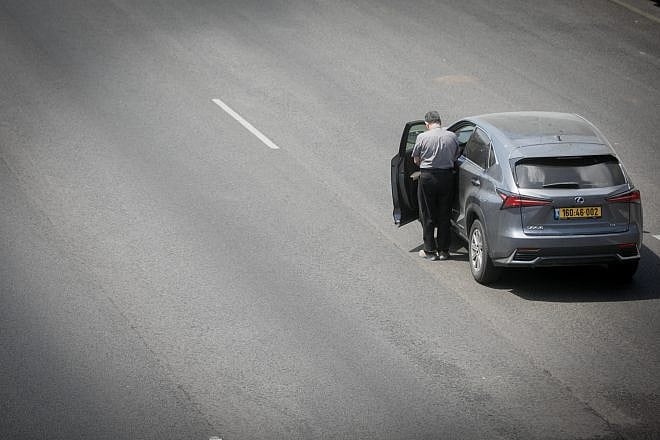 A man stands still as a two-minute siren sounded across Israel, marking Memorial Day, which commemorates the fallen Israeli soldiers and victims of terror, on the Ayalon Highway in Tel Aviv on May 13, 2024. Photo by Miriam Alster/Flash90.