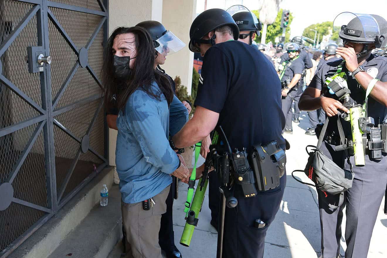A man is arrested by Los Angeles Police Department officers as Israel supporters clash with pro-Palestinian protesters blocking access to the Adas Torah Orthodox Jewish synagogue, in Los Angeles, June 23, 2024. Photo by David Swanson/AFP via Getty Images.