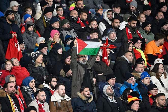 A man displays a PLO flag during the international friendly soccer match between Germany and Turkey at the Olympic Stadium in Berlin in preparation for the UEFA Euro 2024 tournament, Nov. 18, 2023. Photo by Tobias Schwarz/AFP via Getty Images.