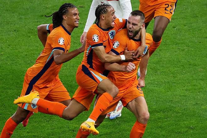 Dutch defender Stefan de Vrij (right) celebrates with defender Nathan Ake (left) and forward Xavi Simons after scoring his team's first goal during the UEFA Euro 2024 quarterfinal match against Turkey at the Olympic Stadium in Berlin on July 6, 2024. Photo by Ronny Hartmann/AFP via Getty Images.