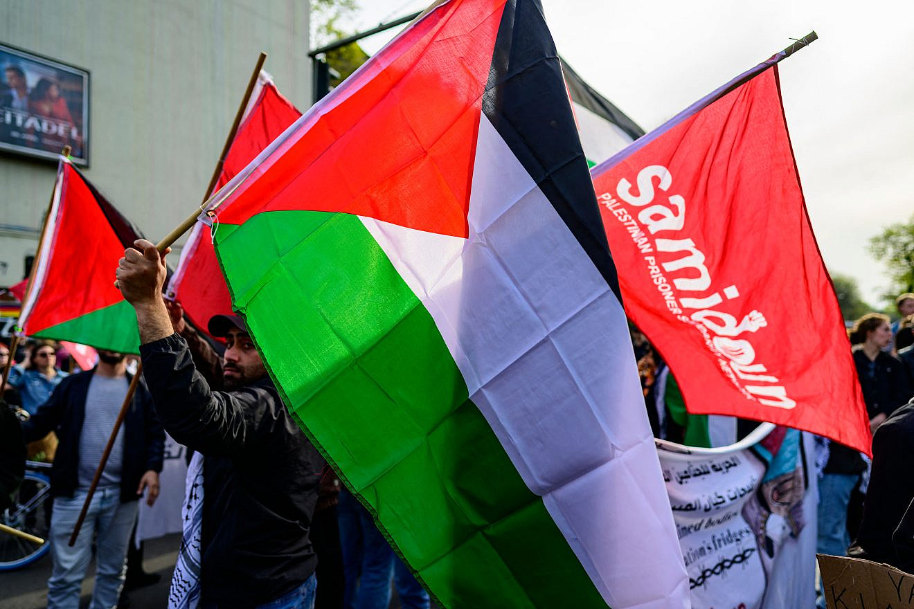 Members of the Samidoun Palestinian Prisoner Solidarity Network wave Palestinian flags during the "Revolutionary May Day" demonstration in Berlin, May 1, 2023. Photo by John MacDougall/AFP via Getty Images.