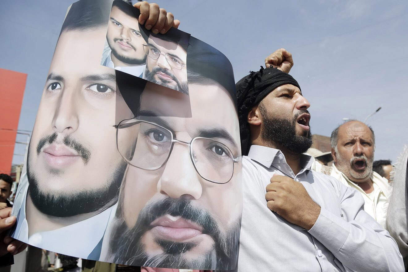 A demonstrator lifts a placard depicting Lebanon's Hezbollah chief Hassan Nasrallah (right) and the leader of the Houthi movement (Ansar Allah) Abdul-Malik Badreddin al-Houthi during a rally in solidarity with Palestinians in Gaza, on Nov. 3, 2023, in Sana'a, Yemen. Photo by Mohammed Hamoud/Getty Images.