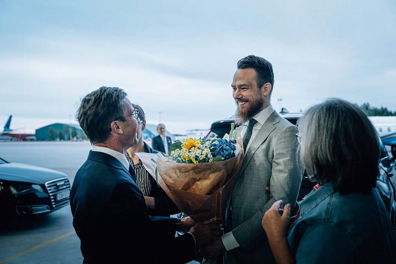 Swedish citizen Johan Floderus (right) is greeted by Swedish Prime Minister Ulf Kristersson upon his arrival at Arlanda airport near Stockholm, on June 15, 2024. Photo by Tom Samuelsson/TT News Agency/AFP via Getty Images.