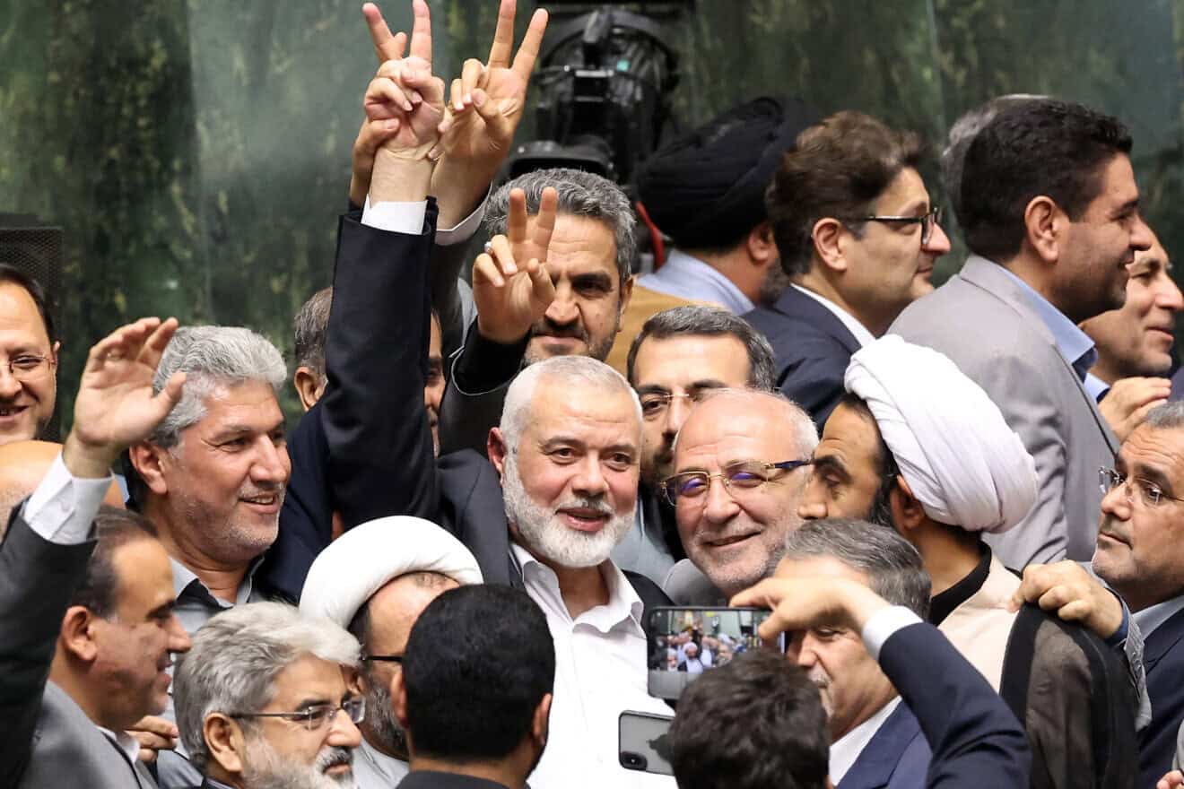 Hamas leader Ismail Haniyeh, surrounded by lawmakers, flashes the victory sign during the swearing in ceremony for the new Iranian president, at the parliament in Tehran on July 30, 2024. Photo by AFP via Getty Images.
