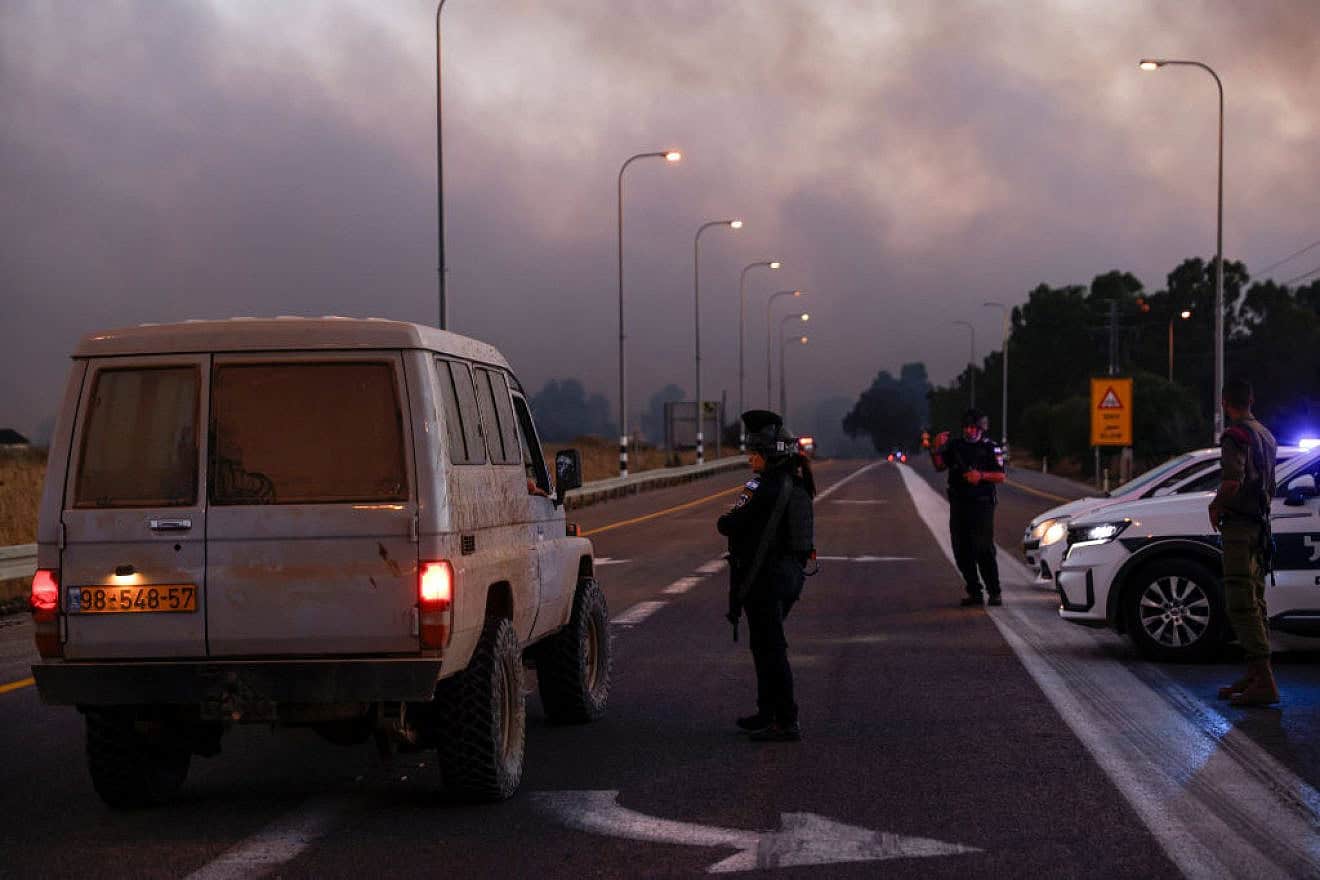 Police secure a road as smoke billows after rockets were fired from Southern Lebanon in the Golan Heights on July 9, 2024. Photo by Jalaa Marey/AFP via Getty Images.