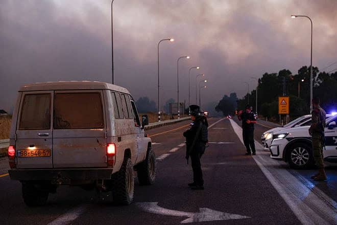 Police secure a road as smoke billows after rockets were fired from Southern Lebanon in the Golan Heights on July 9, 2024. Photo by Jalaa Marey/AFP via Getty Images.