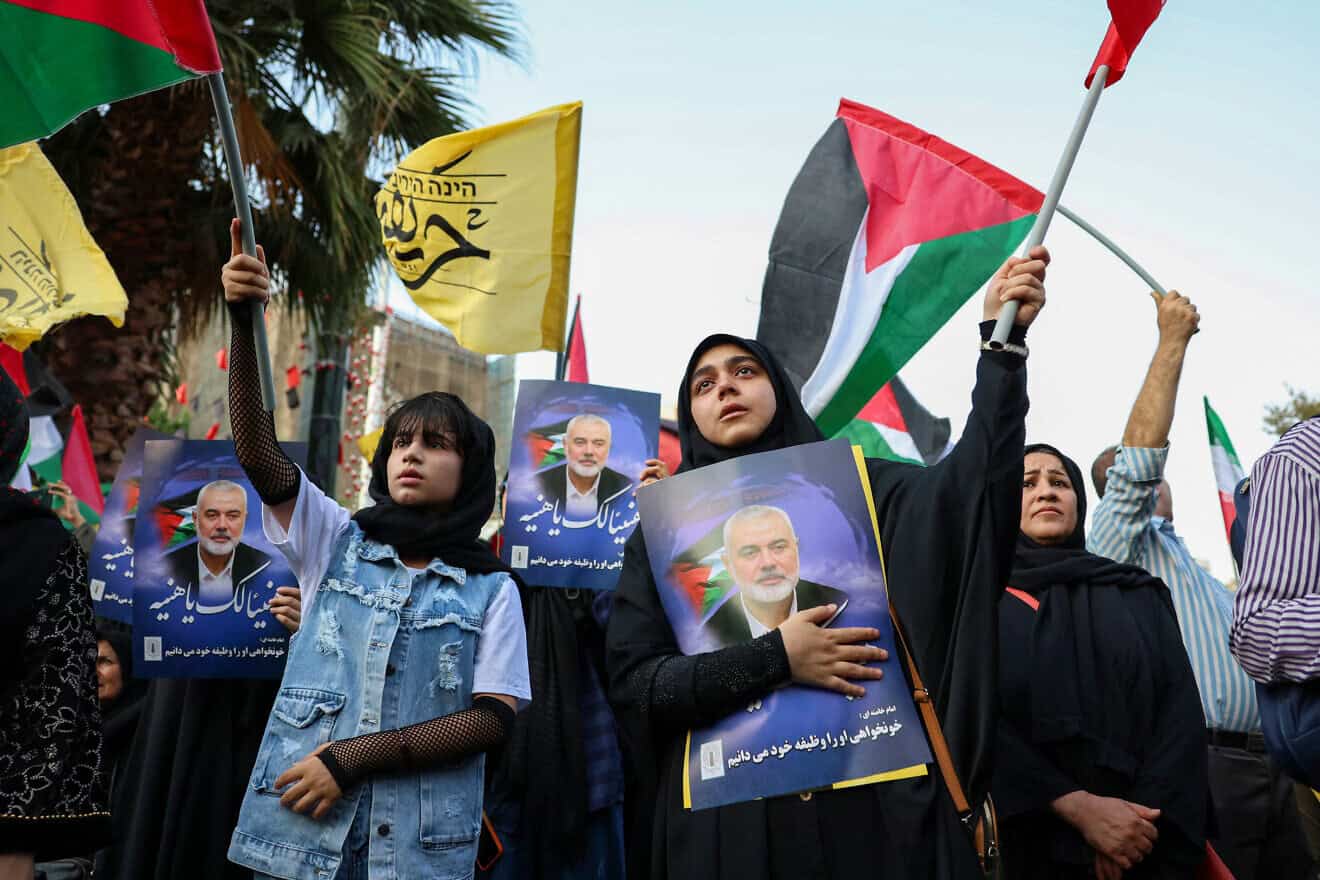 Iranians wave Palestinian flags and hold portraits of slain Hamas leader Ismail Haniyeh during a protest denouncing his killing, at Palestine square in the capital Tehran on July 31, 2024. Photo by/AFP via Getty Images.