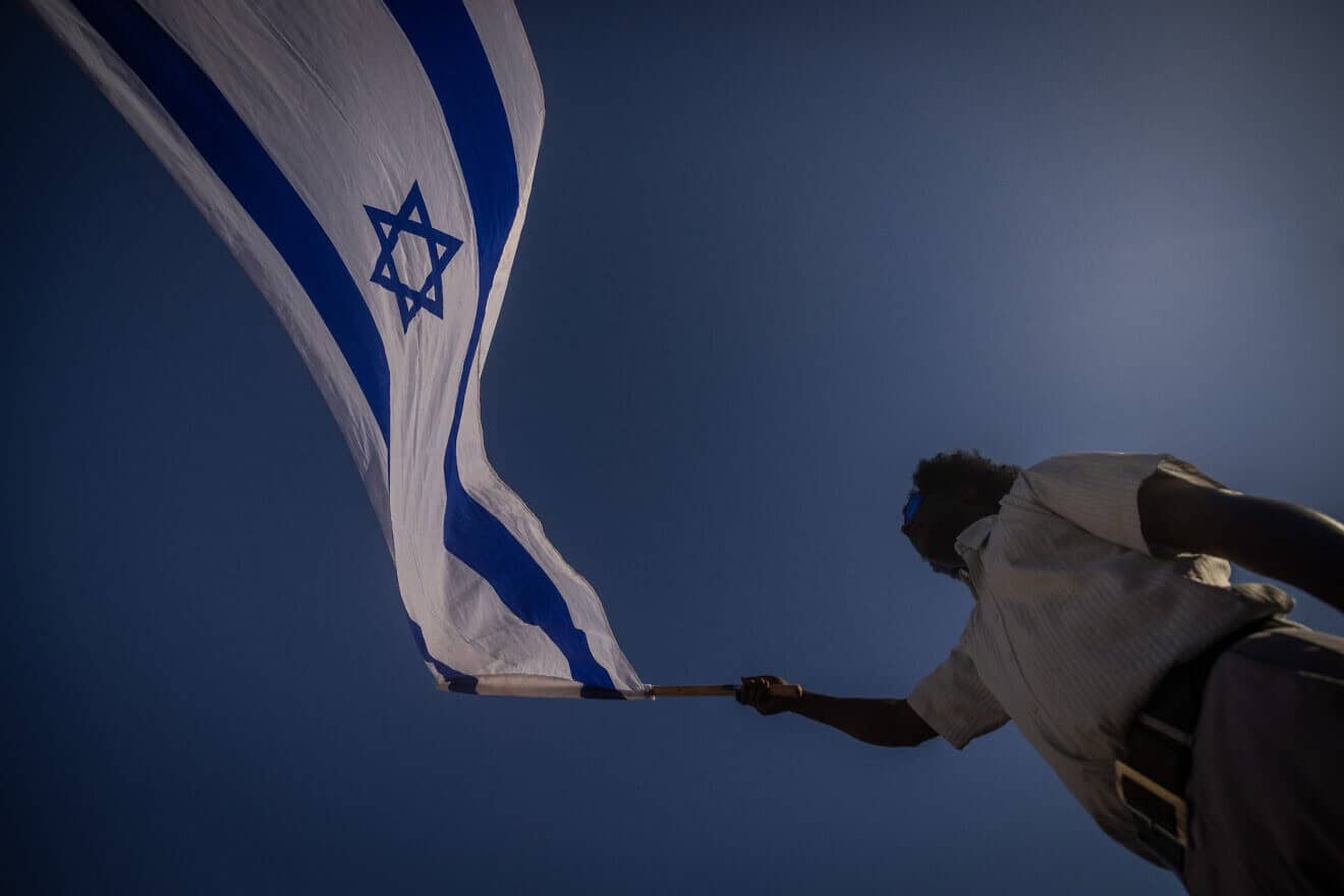 A man waves an Israeli flag at Damascus Gate in the Old City during Jerusalem Day celebrations on June 5, 2024. Photo by Chaim Goldberg/Flash90.