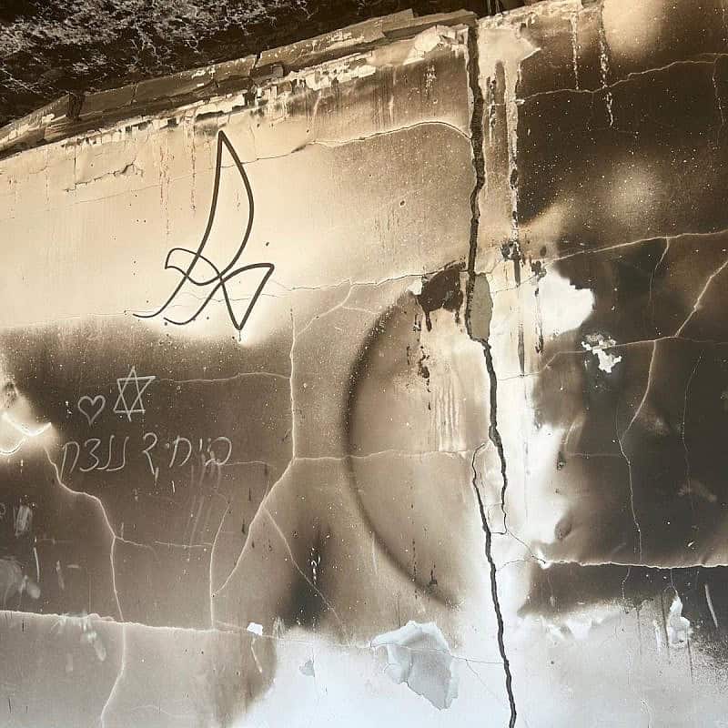 The remains of a house in Kibbutz Be'eri in southern Israel, July 22, 2024. The drawing on the wall reads: “Together, we will win.” Photo by Amelie Botbol.
