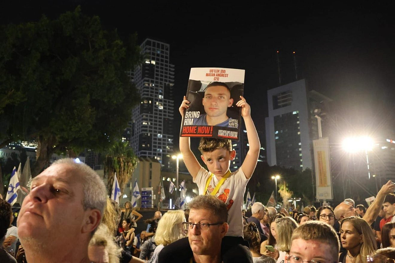 Roi Angrest holds a poster depicting his brother Matan at a protest. Credit: The Hostages and Missing Families Forum.