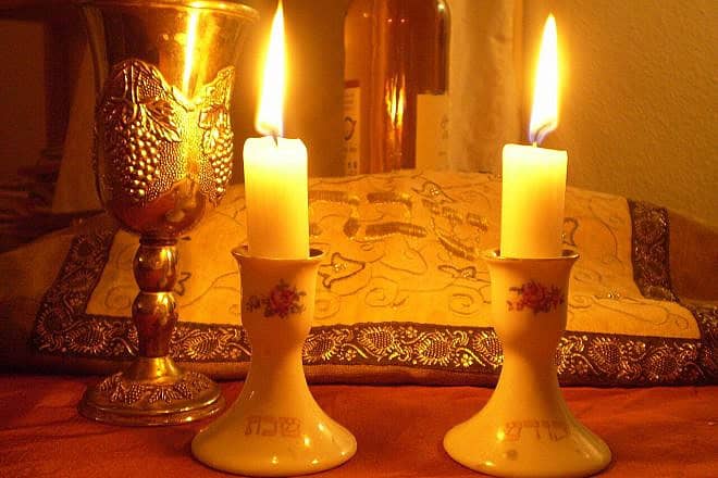 Shabbat candles and covered challah. Credit: Olaf.herfurth via Wikimedia Commons.