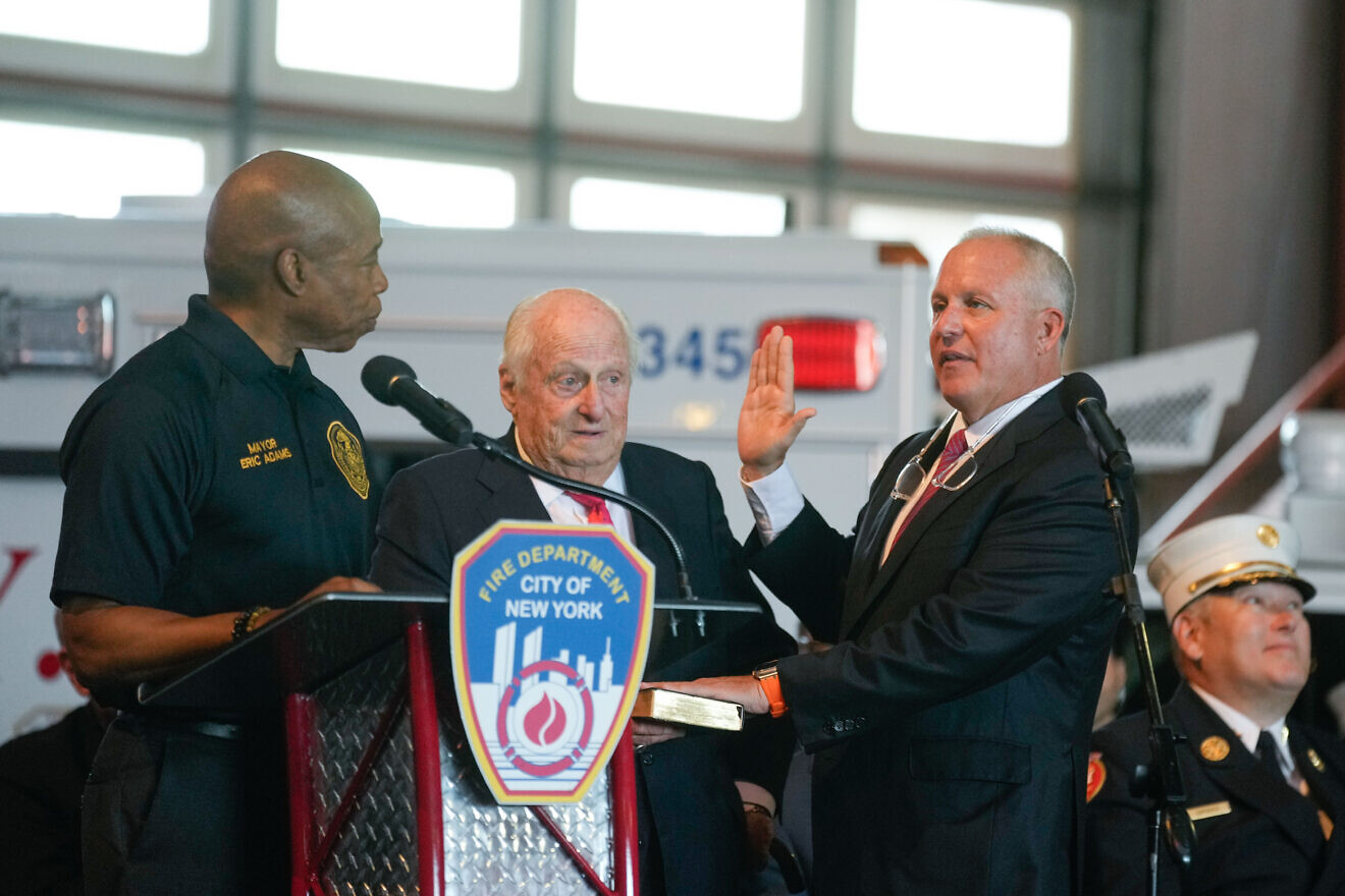 New York City Mayor Eric Adams swears in Robert Tucker as the 35th commissioner of the New York City Fire Department using a Tanach from Tucker's bar mitzvah which his father Barry Tucker holds at the Fire Academy on Randalls and Wards Islands on Aug. 12, 2024. Credit: Michael Appleton/Mayoral Photography Office.