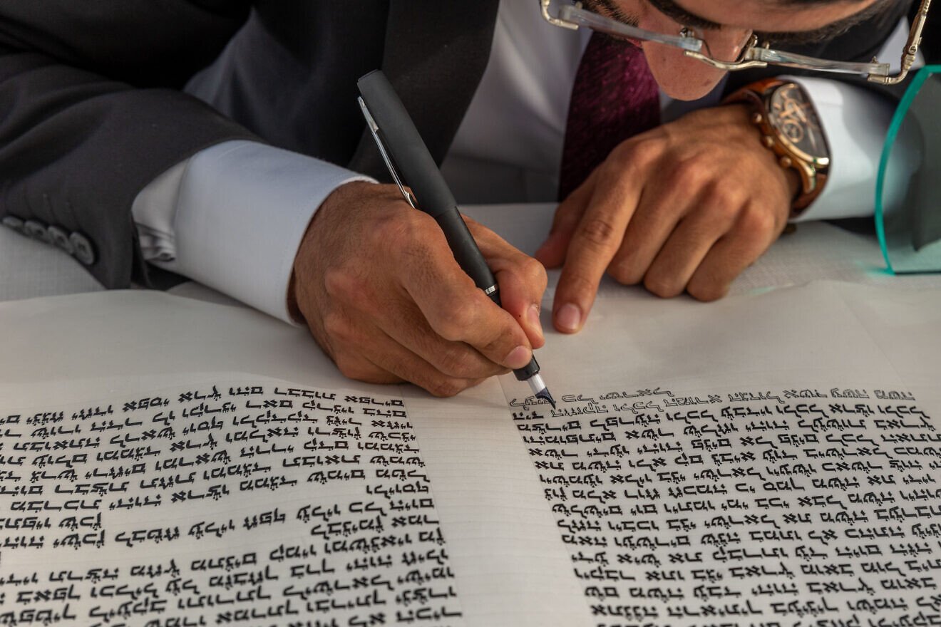 A man fills in letters in a Torah scroll in Moshav Yashresh, Aug. 25, 2022. Photo by Yossi Aloni/Flash90.