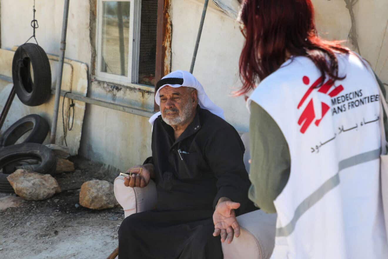 A Doctors Without Borders (MSF) charity coordinator speaks with a Palestinian in Susya village in Judea on July 17, 2024. Photo by Mosab Shawer/AFP via Getty Images.