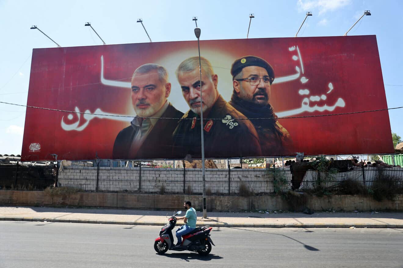 A billboard with portraits of slain Hamas terrorist Ismail Haniyeh, Iranian Quds Force Commander Qassem Soleimani and top Hezbollah commander Fuad Shukr on a main road near Beirut International Airport, Aug. 3, 2024. Photo by Ibrahim Amro/AFP via Getty Images.