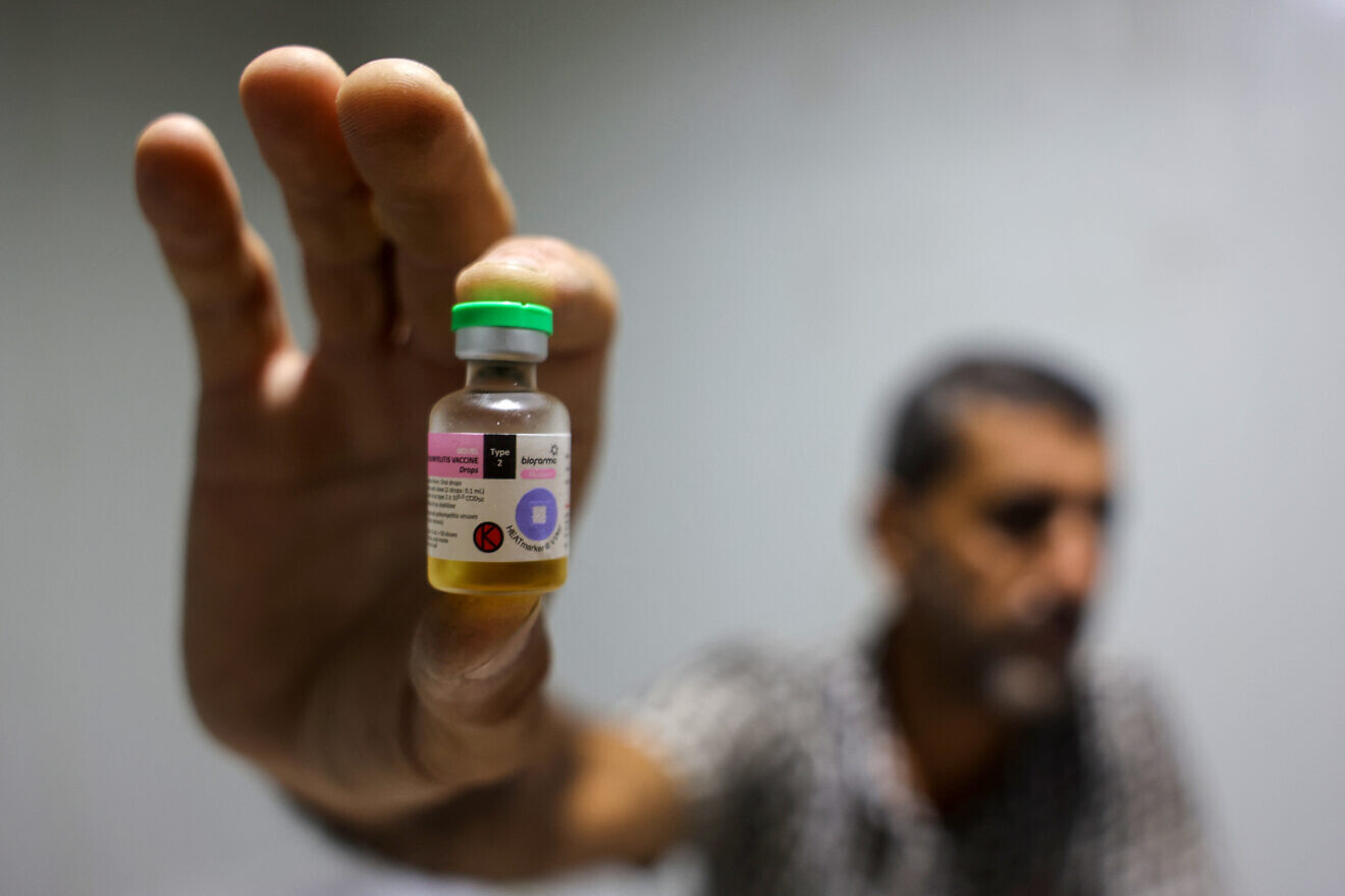 A worker shows a vial containing a polio vaccine provided with support from UNICEF to the Gaza Strip through the Kerem Shalom border crossing, at a depot belonging to Gaza's health ministry, which is run by Hamas, on Aug. 25, 2024. Photo by Eyad Baba/AFP via Getty Images.