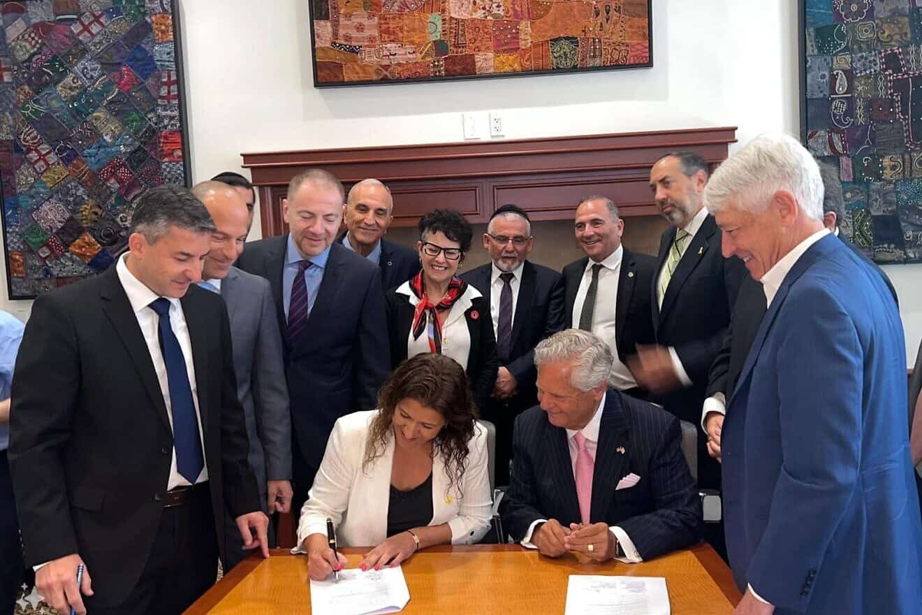 Ifat Ovadia-Luski, chairwoman of KKL-JNF, and Dr. Sol Lizerbram, president of JNF-USA, sign the agreement. Photo by Gabby Lipton.