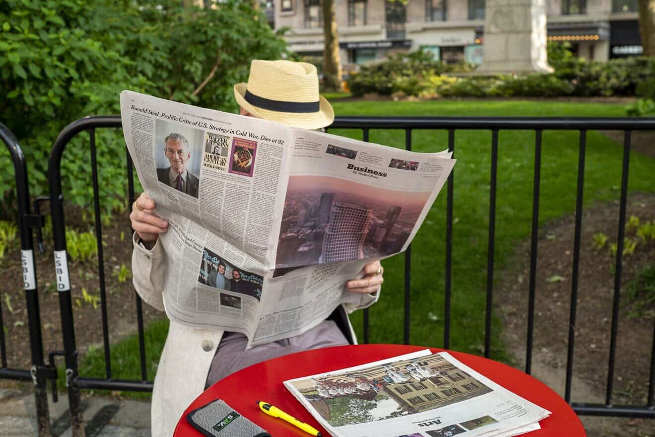 A man reads the newspaper in a park in New York City. Photo by Robert Nickelsberg/Getty Images.
