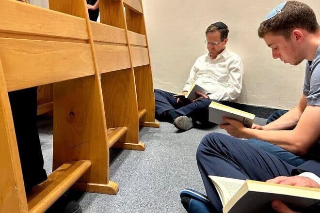 Israeli President Isaac Herzog participates in a reading of the Book of Lamentations at the Ohel Nechama Synagogue in Jerusalem. The book recounts the destruction of the Temple in Jerusalem and is traditionally recited sitting on the floor as a sign of mourning, July 13, 2024. Credit: Courtesy.