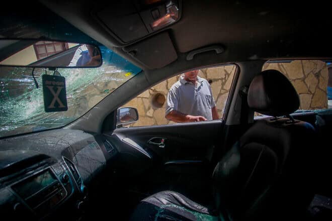 A Palestinian inspects a damaged car after Israelis allegedly threw stones at it at the Awarta checkpoint, south of Nablus, on Aug. 9, 2024. Photo by Nasser Ishtayeh/Flash90.