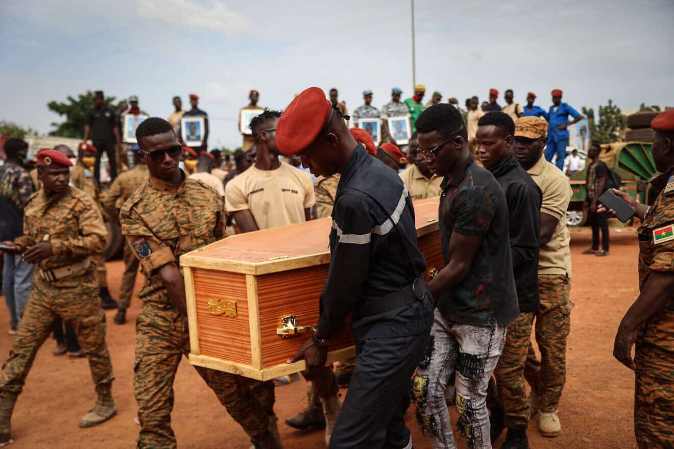 Burkina Faso's servicemen carry a coffin during the burial of the soldiers killed in Gaskinde, in Ouagadougou on Oct. 8, 2022. The ambush in Gaskinde, claimed by Al-Qaeda, officially killed 37 people, including 27 soldiers on Sept. 26, 2022. Photo by Oympia De Miasmont/AFP via Getty Images.