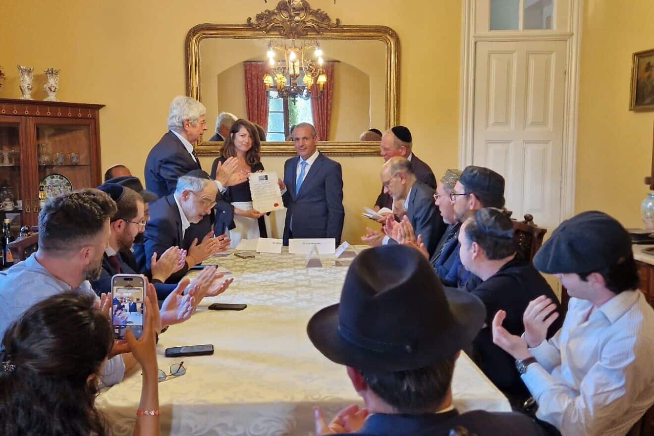 Shira Granot, director of community engagement at the Combat Antisemitism Movement,  receives the tribute to the Mukhariq initiative on behalf of CAM from Luis Eduardo Afonso Andrade, president of the International Observatory for Human Rights. Credit: Courtesy.