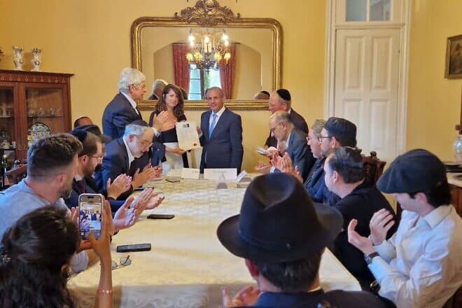 Shira Granot, director of community engagement at the Combat Antisemitism Movement,  receives the tribute to the Mukhariq initiative on behalf of CAM from Luis Eduardo Afonso Andrade, president of the International Observatory for Human Rights. Credit: Courtesy.