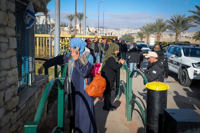 Palestinian workers line up at the entrance to the Israeli city of Ma'ale Adumim in Judea following an attempted stabbing attack, Feb. 23, 2023. Photo by Jamal Awad/Flash90.