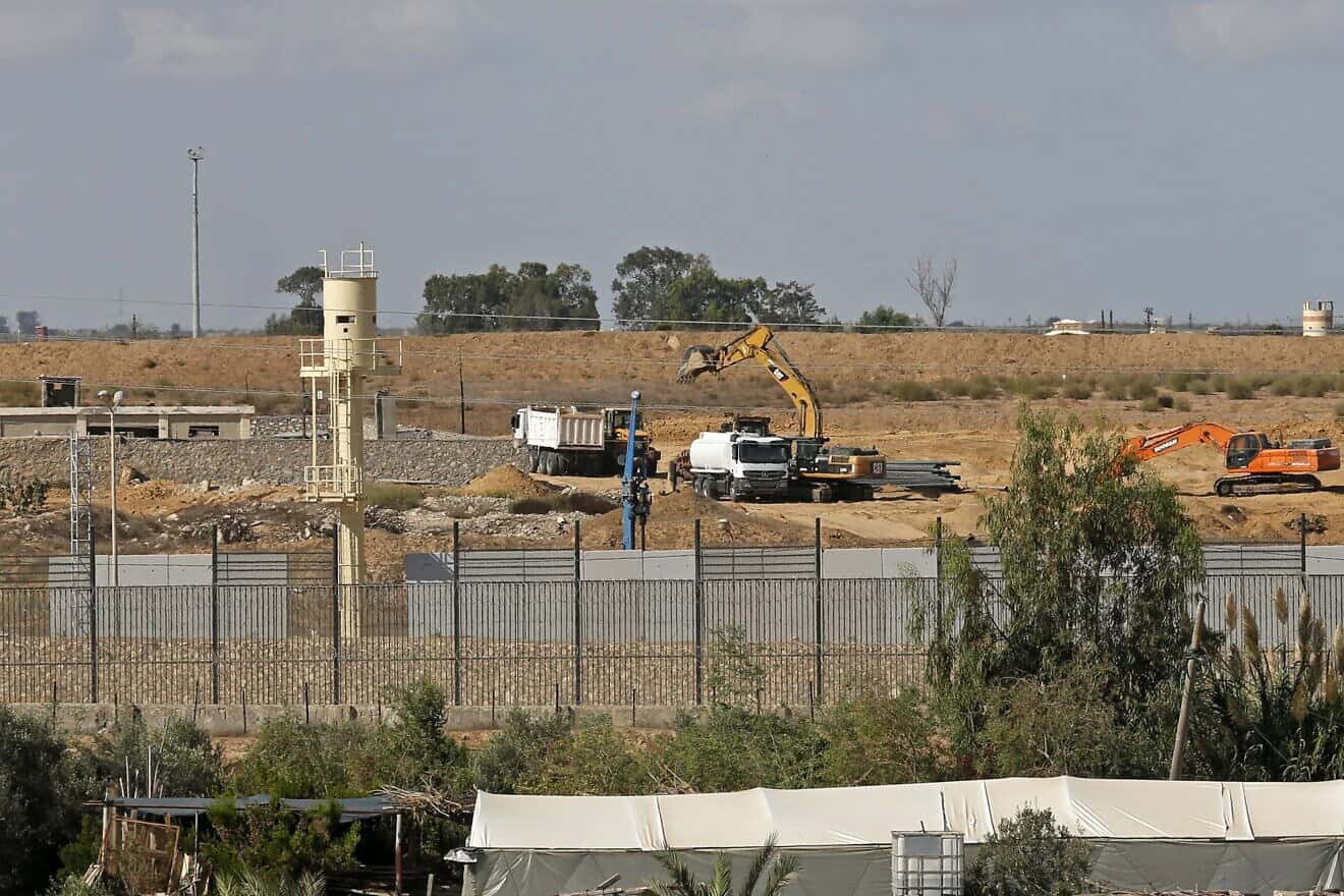A picture taken from the southern Gaza Strip city of Rafah at the border with Egypt shows a crane laying down concrete blocks to build a wall along the Egyptian border with Gaza on Oct. 4, 2020. Photo by Said Khatib/AFP via Getty Images.