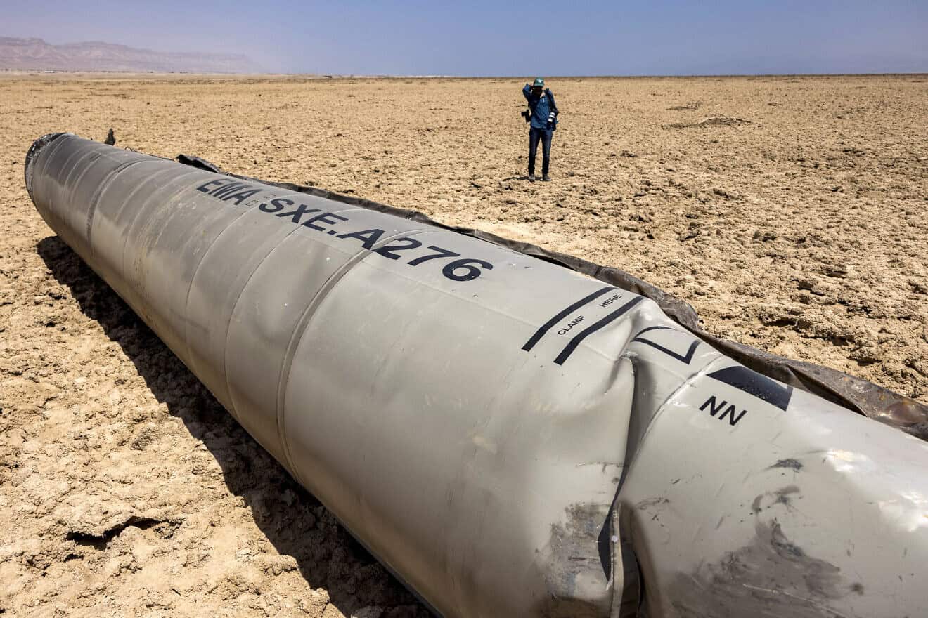 A photographer approaches the remains of a missile that landed on the shore of the Dead Sea, April 21, 2024. Photo by Menahem Kahana/AFP via Getty Images.