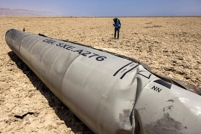 A photographer approaches the remains of an Iranian missile that landed on the shore of the Dead Sea, April 21, 2024. Photo by Menahem Kahana/AFP via Getty Images.