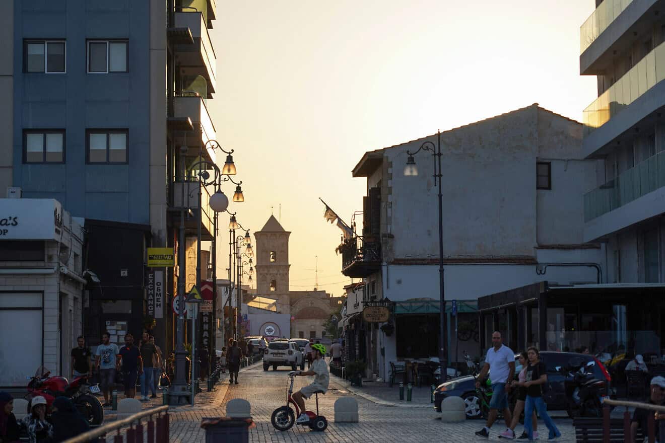 People walk across from the Church of Saint Lazarus in Larnaca, Cyprus at sunset on Aug. 11, 2024. (Photo by Etienne Torbey/AFP via Getty Images.