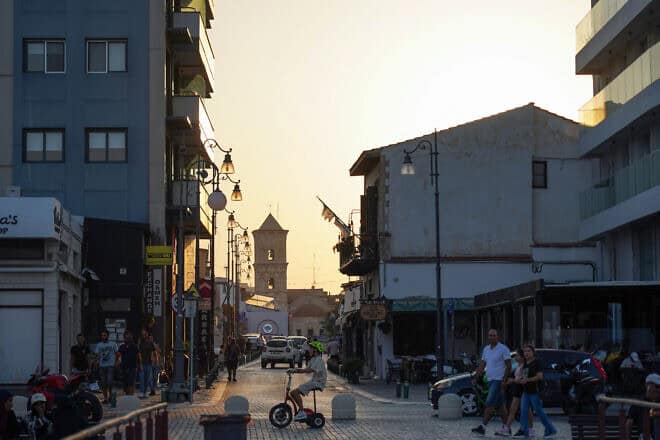 People walk across from the Church of Saint Lazarus in Larnaca, Cyprus at sunset on Aug. 11, 2024. (Photo by Etienne Torbey/AFP via Getty Images.