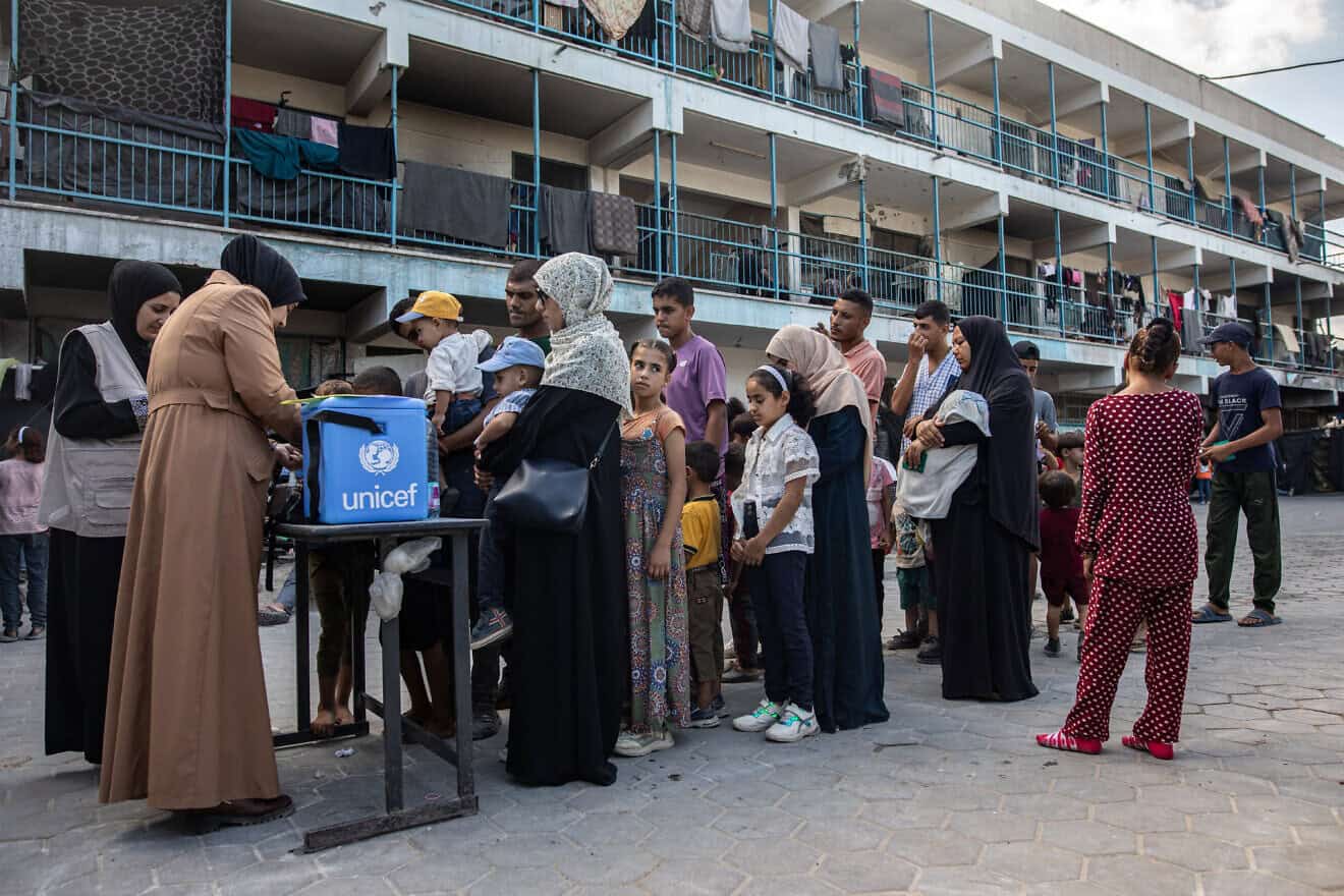 People queue with their children for polio vaccinations at a makeshift camp for those displaced by conflict in a school run by UNRWA in Khan Younis in the southern Gaza Strip on Sept. 5, 2024. Photo by Bashar Taleb/AFP via Getty Images.